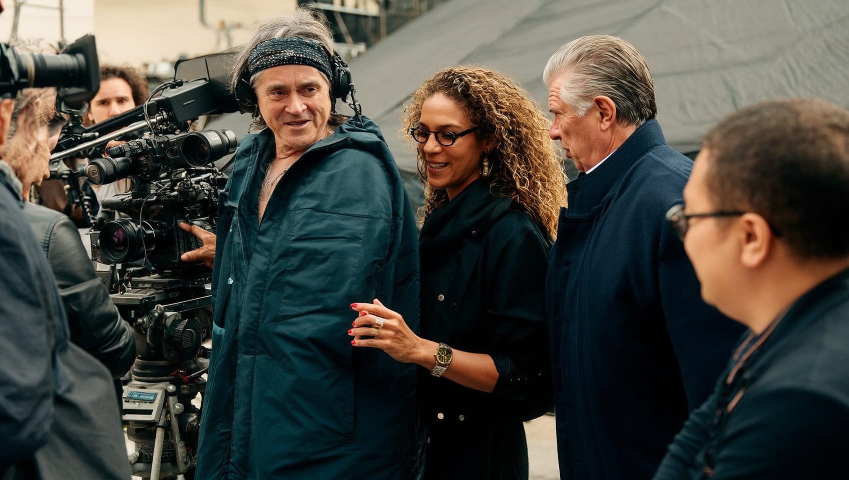 Director speaking with a cinematographer beside the camera during a live take